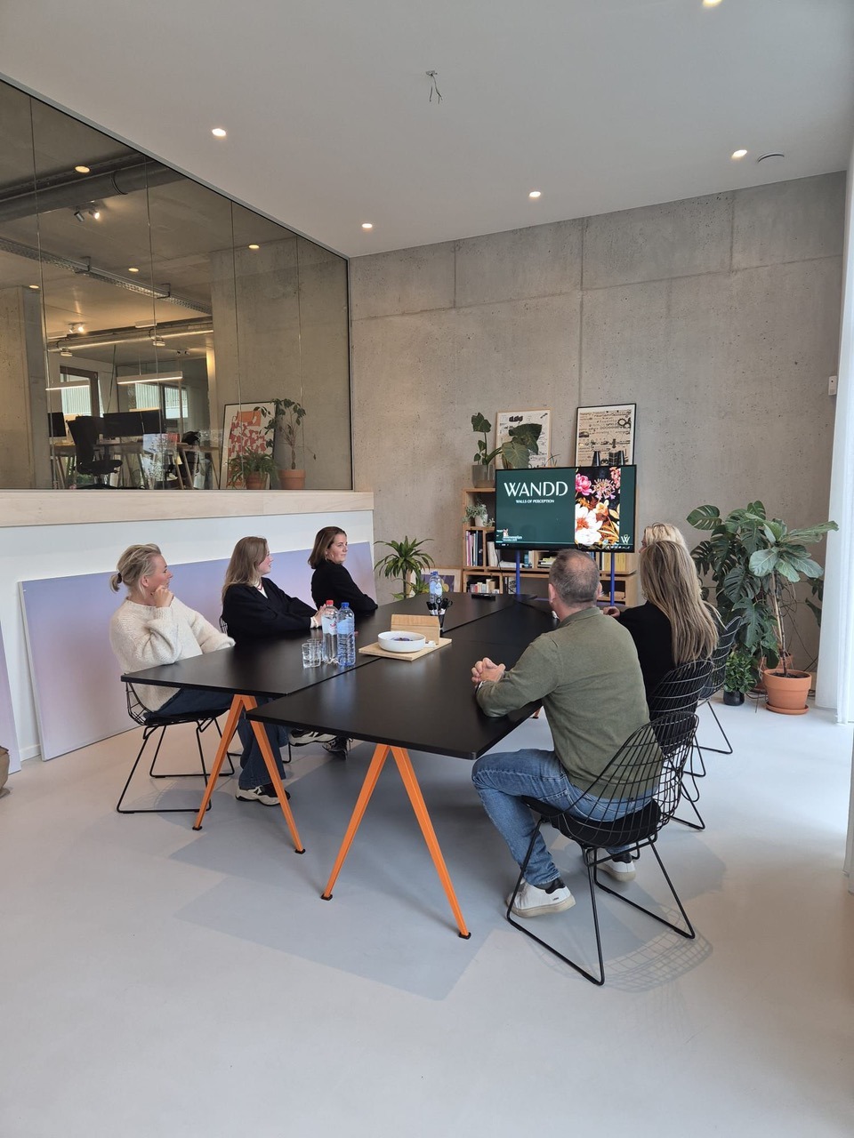 Team vergadert aan de grote tafel met presentatiescherm bij Locatie 1196 in Breda